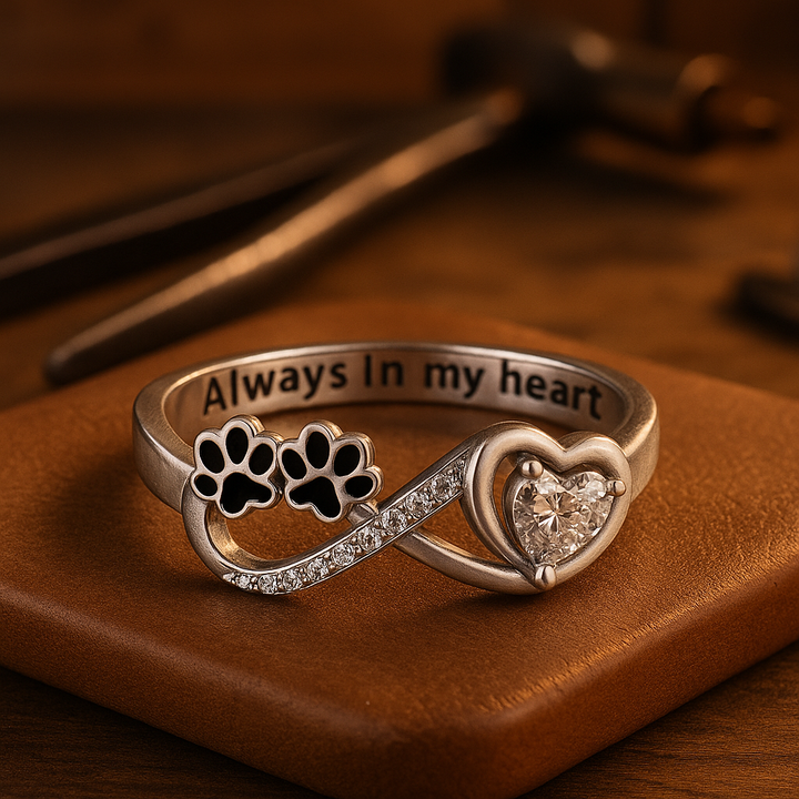 Ring with paw-shaped zirconia, heart and infinity symbol.