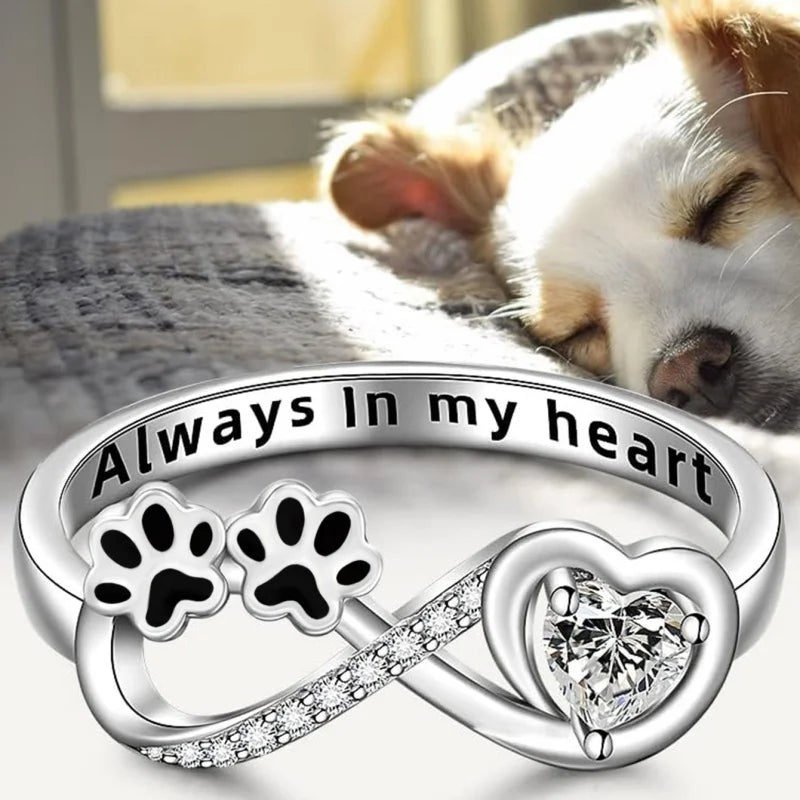 Ring with paw-shaped zirconia, heart and infinity symbol.