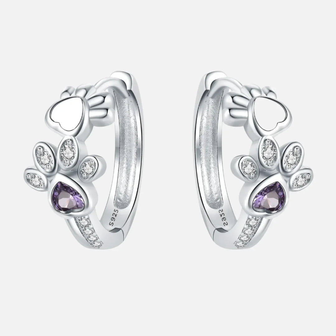 Silver earrings with paw print, zirconia, and a heart-shaped gemstone.