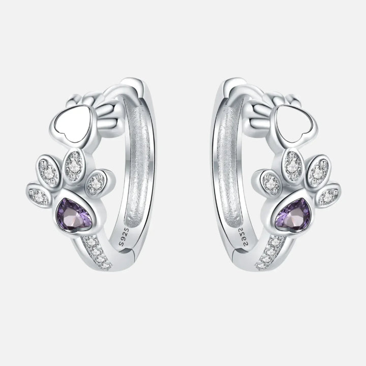 Silver earrings with paw print, zirconia, and a heart-shaped gemstone.