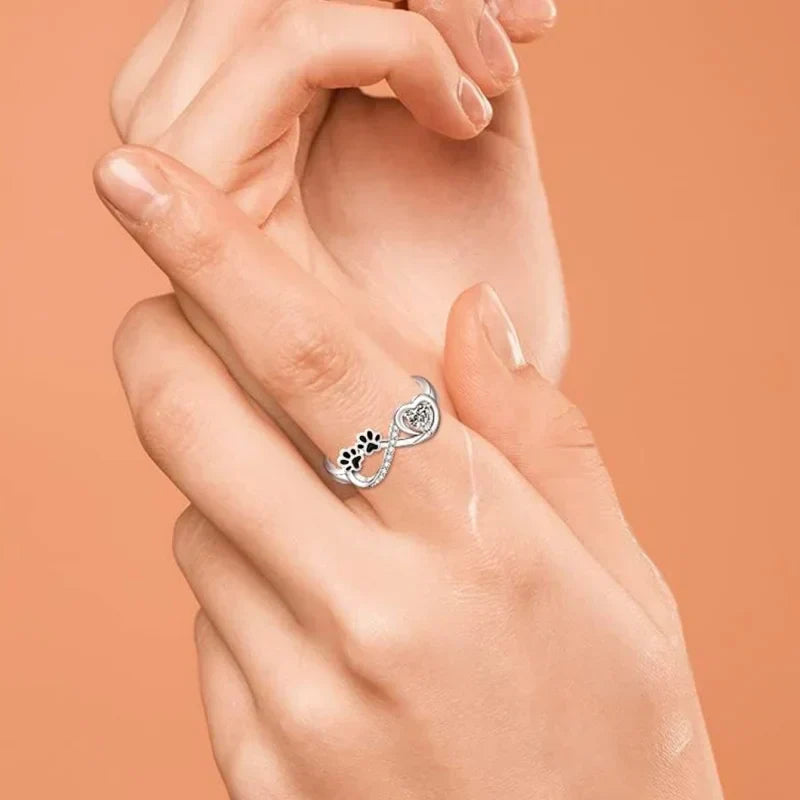 Ring with paw-shaped zirconia, heart and infinity symbol.